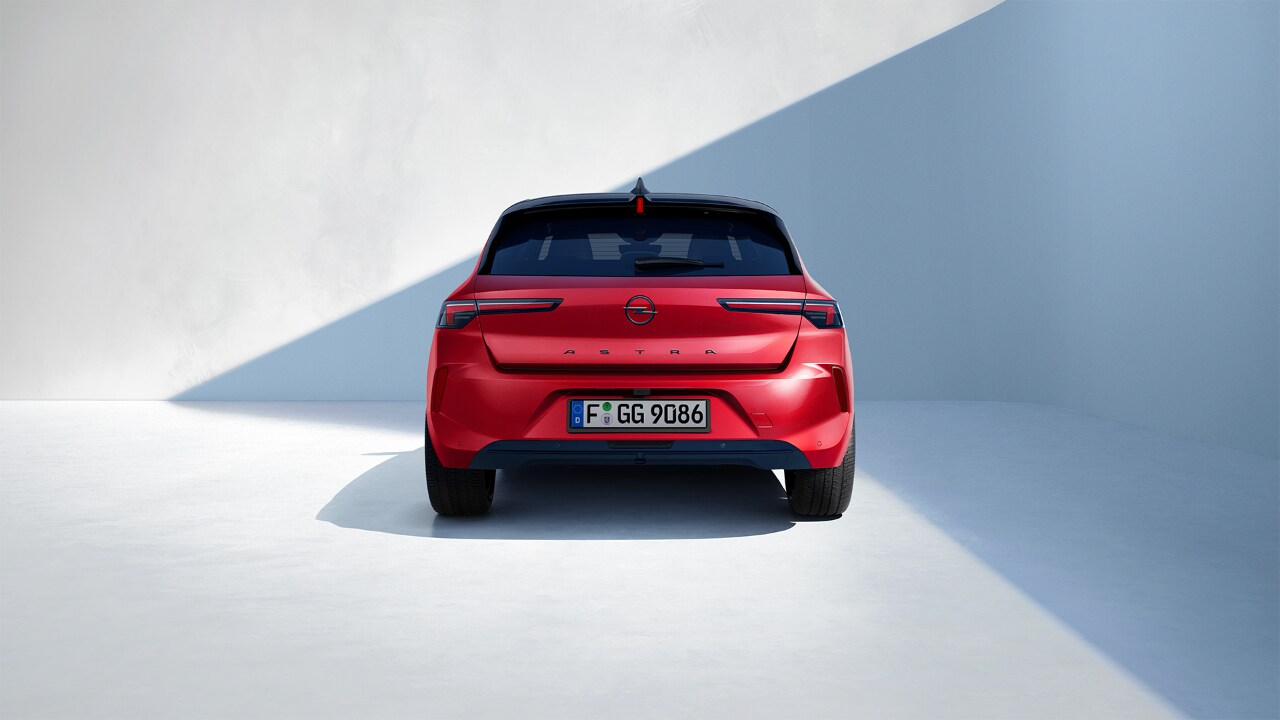 Vista trasera de un Opel Astra rojo con techo negro